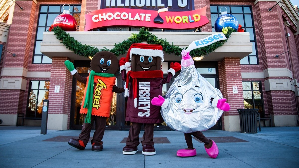 Characters in holiday gear in front of HERSHEY'S CHOCOLATE WORLD