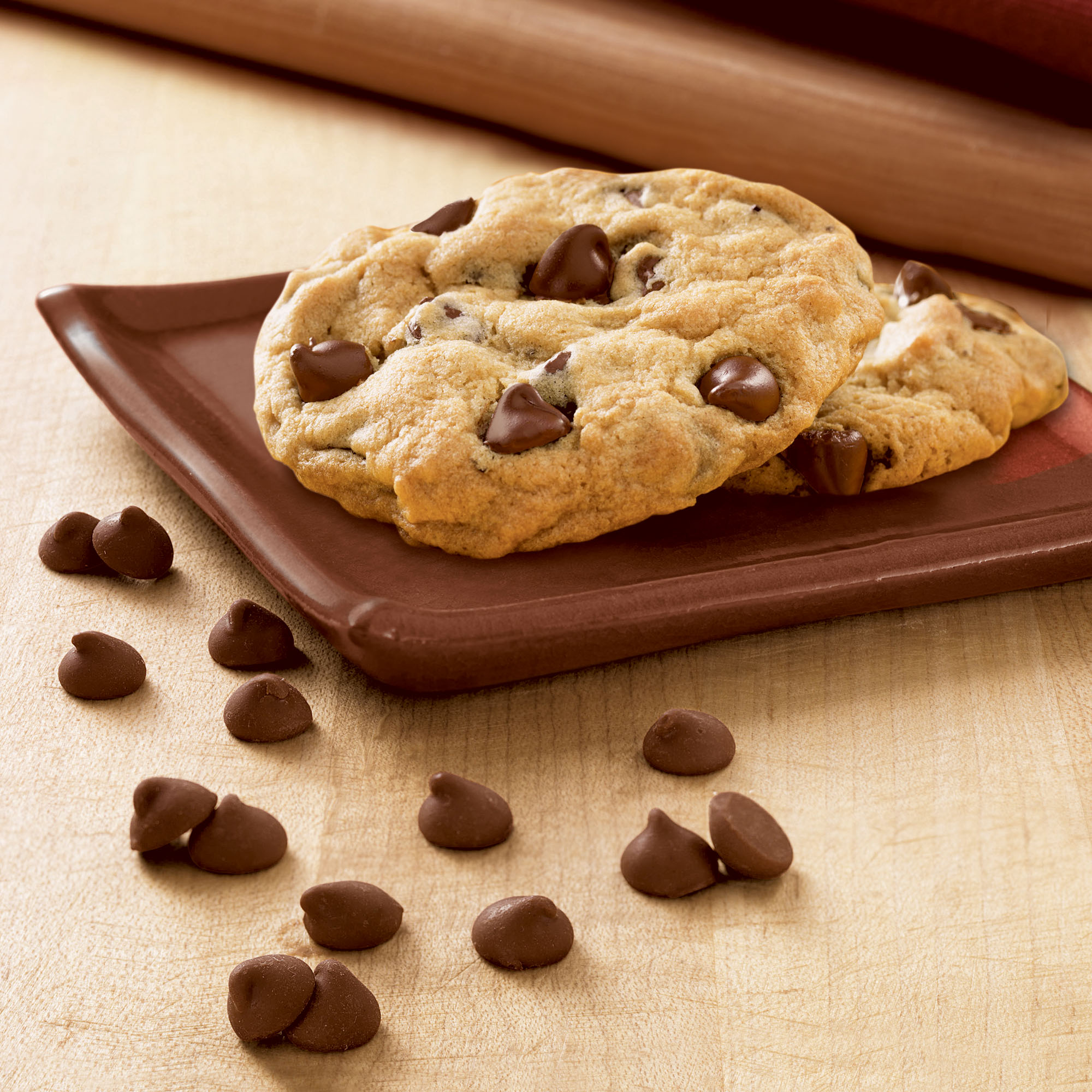 Chocolate Chip Cookie on a table next to additional chips