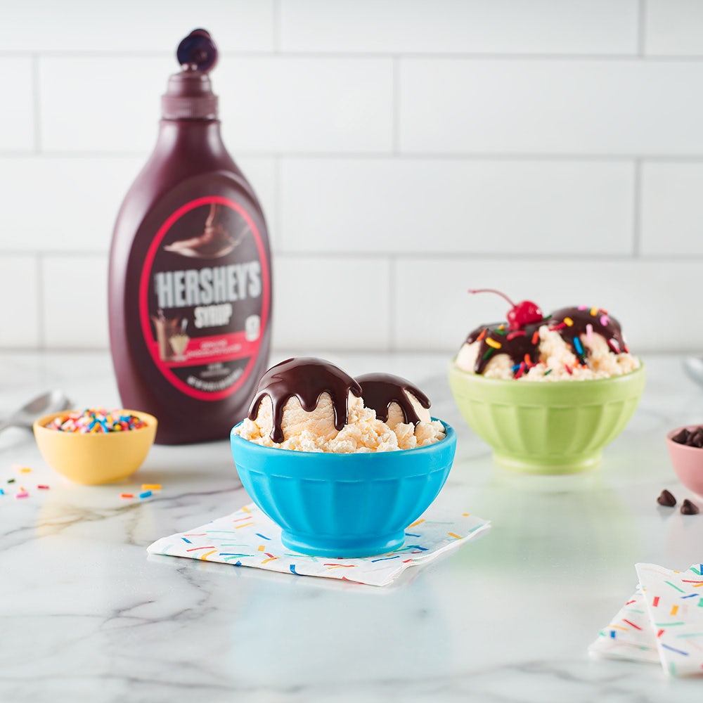 ice cream sundaes topped with hersheys chocolate syrup and assorted toppings